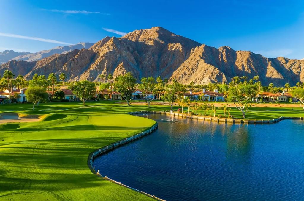 A sweeping golf course framed by mountains and water
